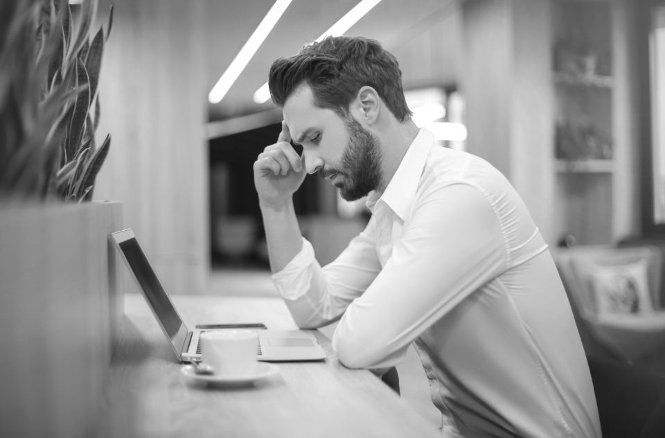 A man at his desk with his head in his hand